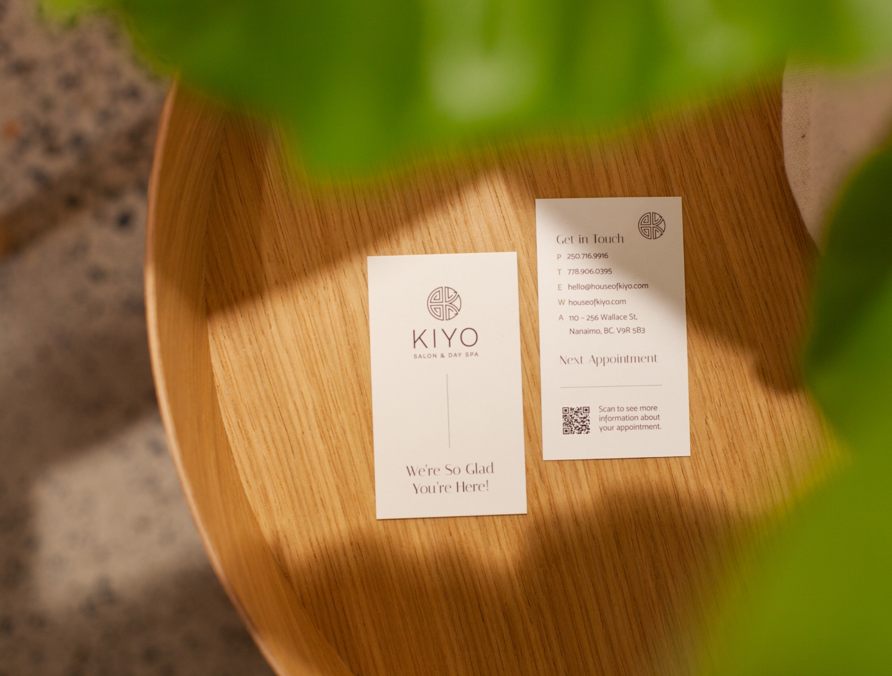 Pair of House of Kiyo business cards on a wooden table.