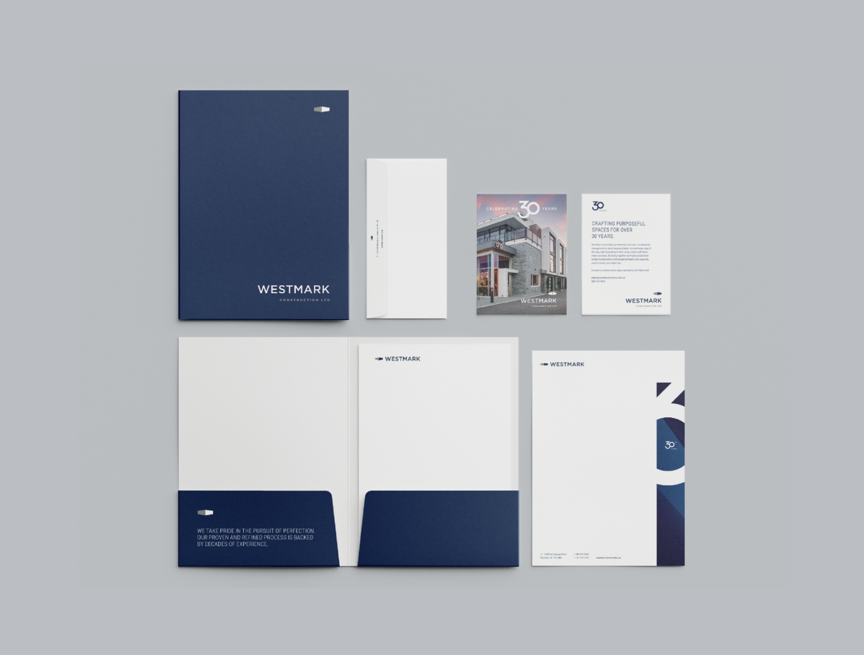 A collection of sleek, minimalist office stationery with Westmark branding, including folders, an envelope, and letterheads.