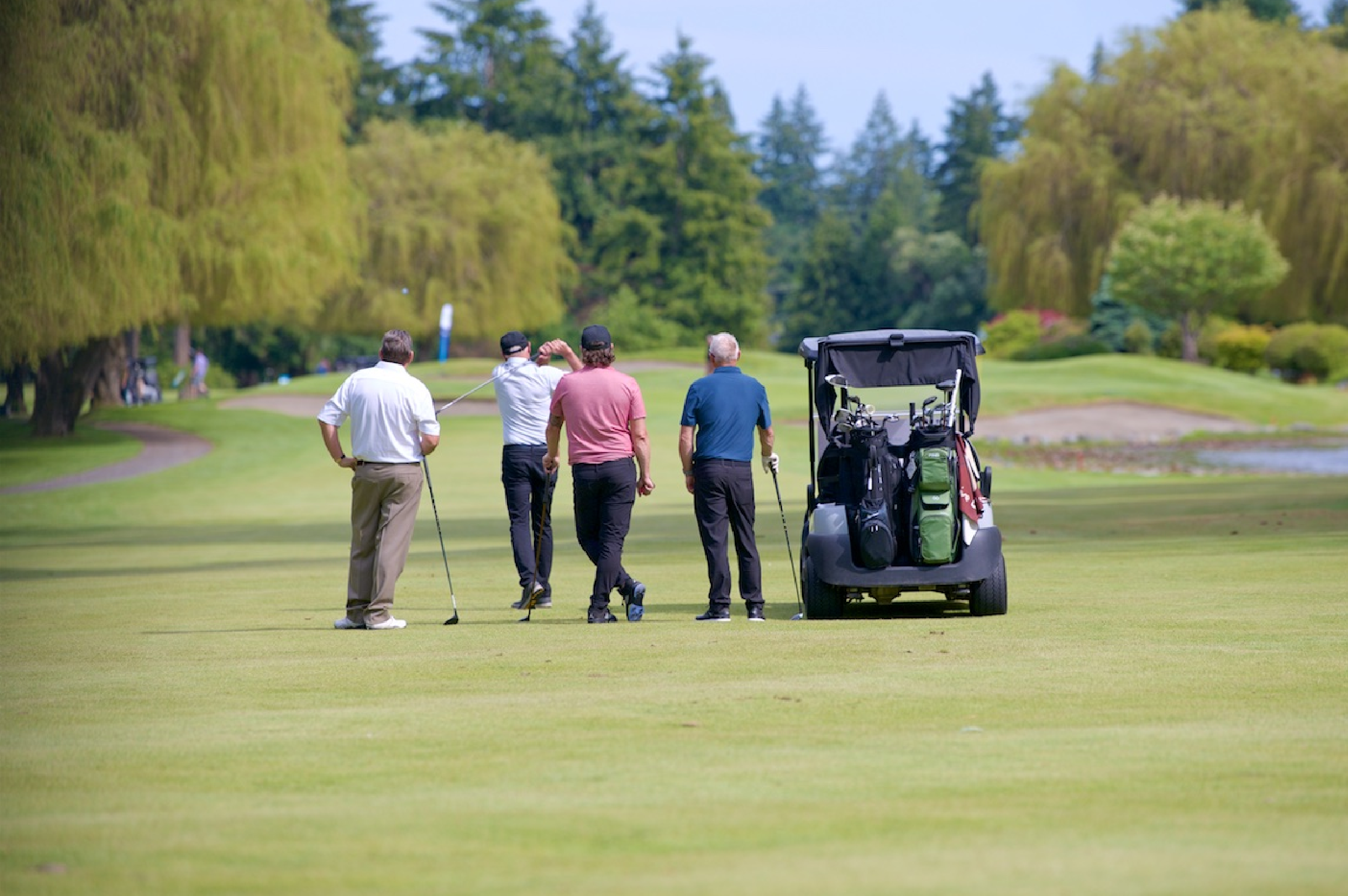 Men on a golf course for the Tom Harris Charity Classic event.